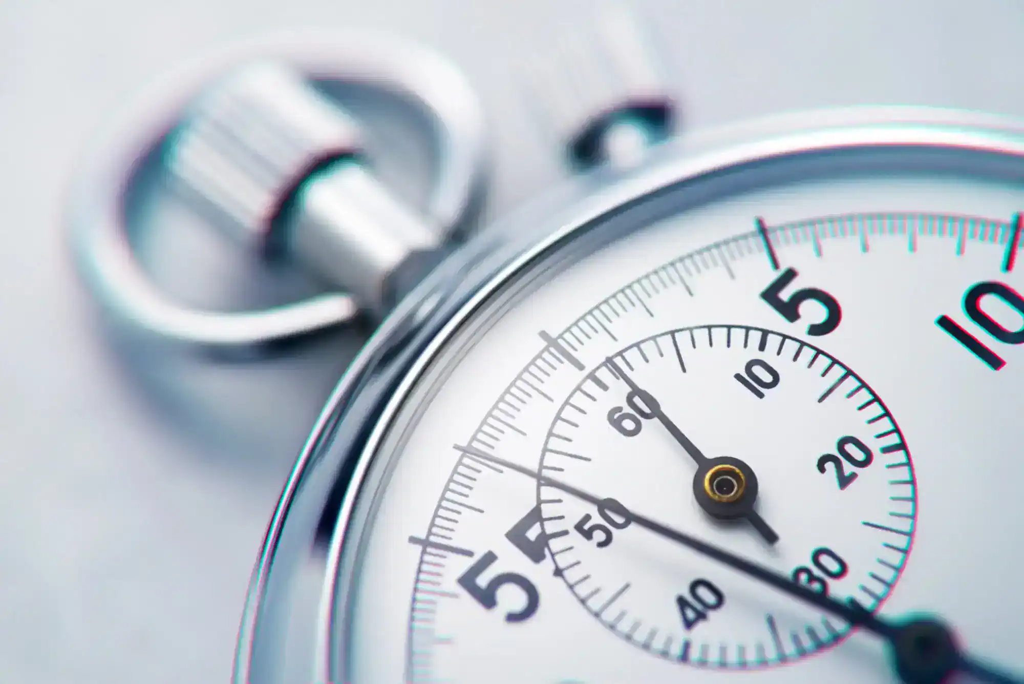 Close-up of a stopwatch face showing seconds, with the dial and metal button in soft focus.