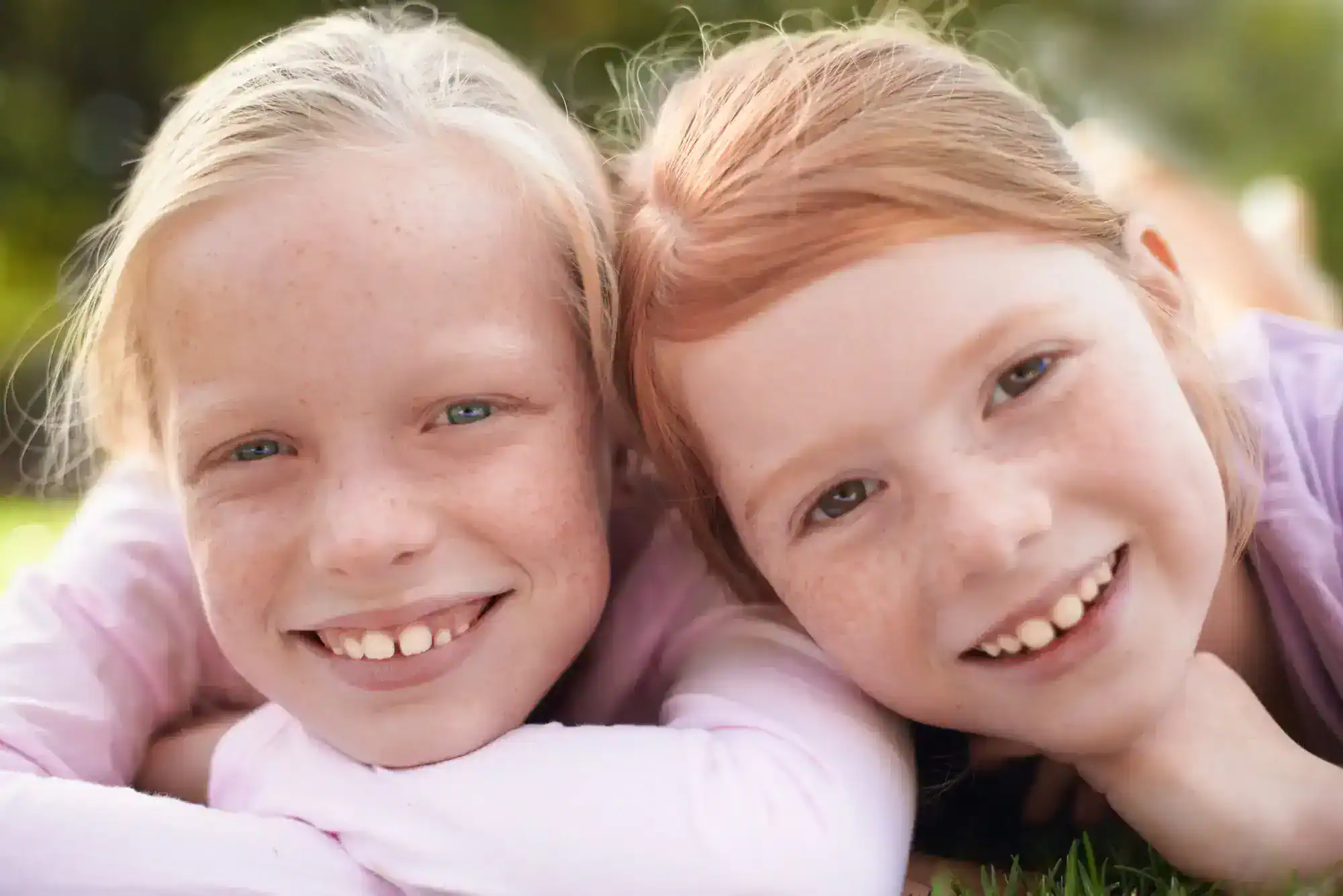 Two little girls smiling. They seem to be best friends.