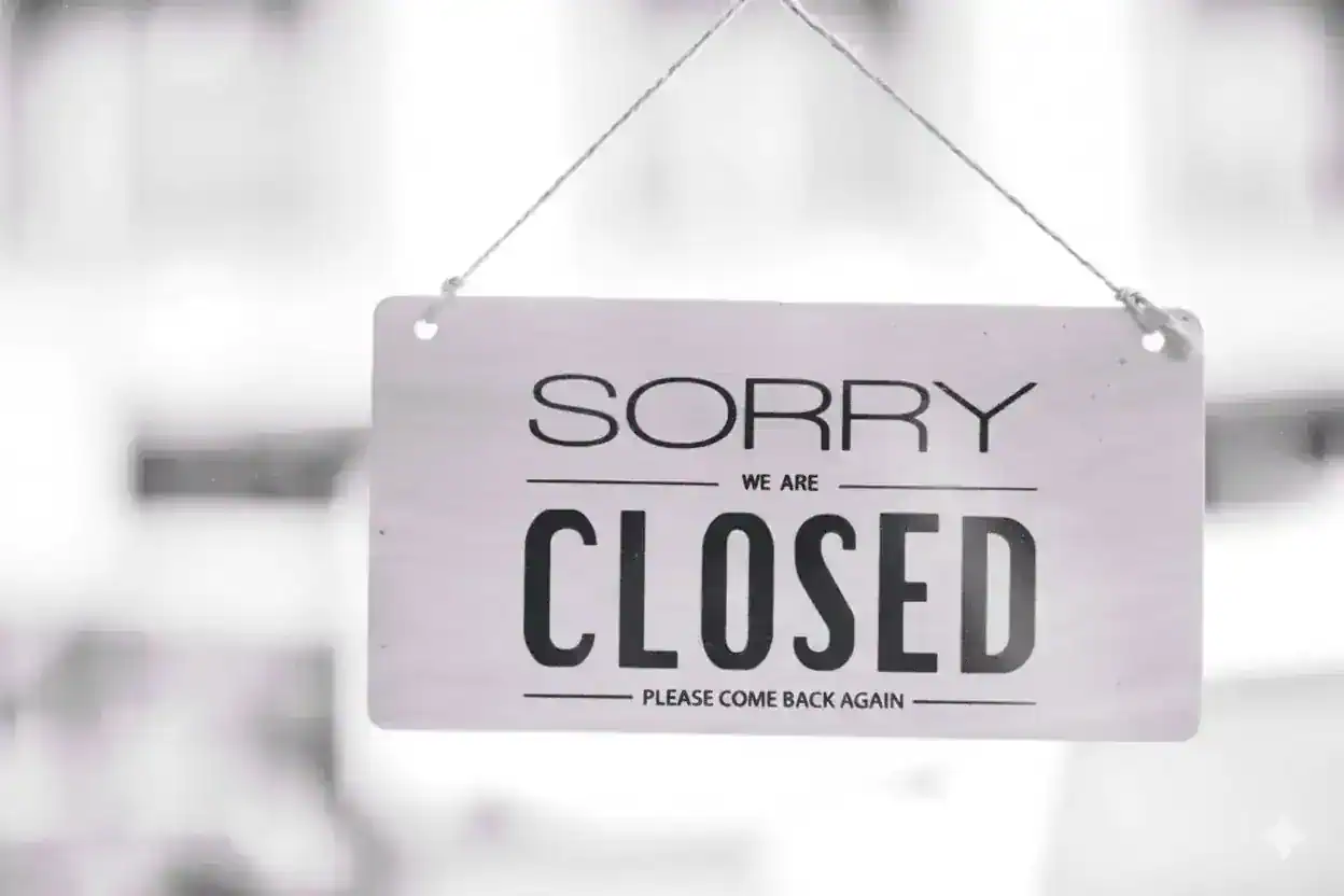 Sign on a glass door writing “Sorry, we are closed”.