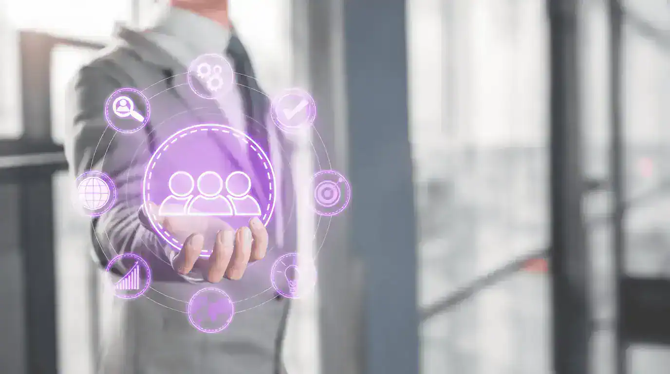 A man in a suit holding a round graphic with several contact and connection icons.