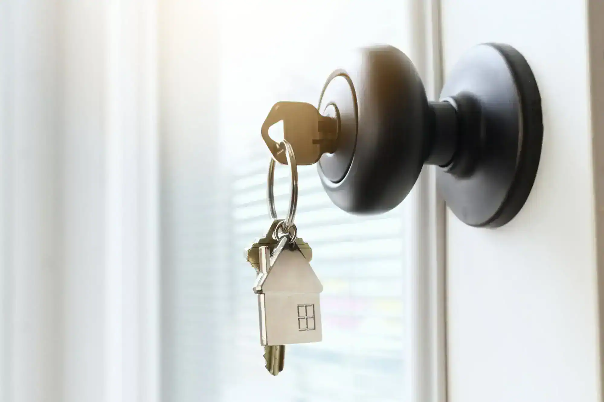 A key ring with a house on it on the door of a business.