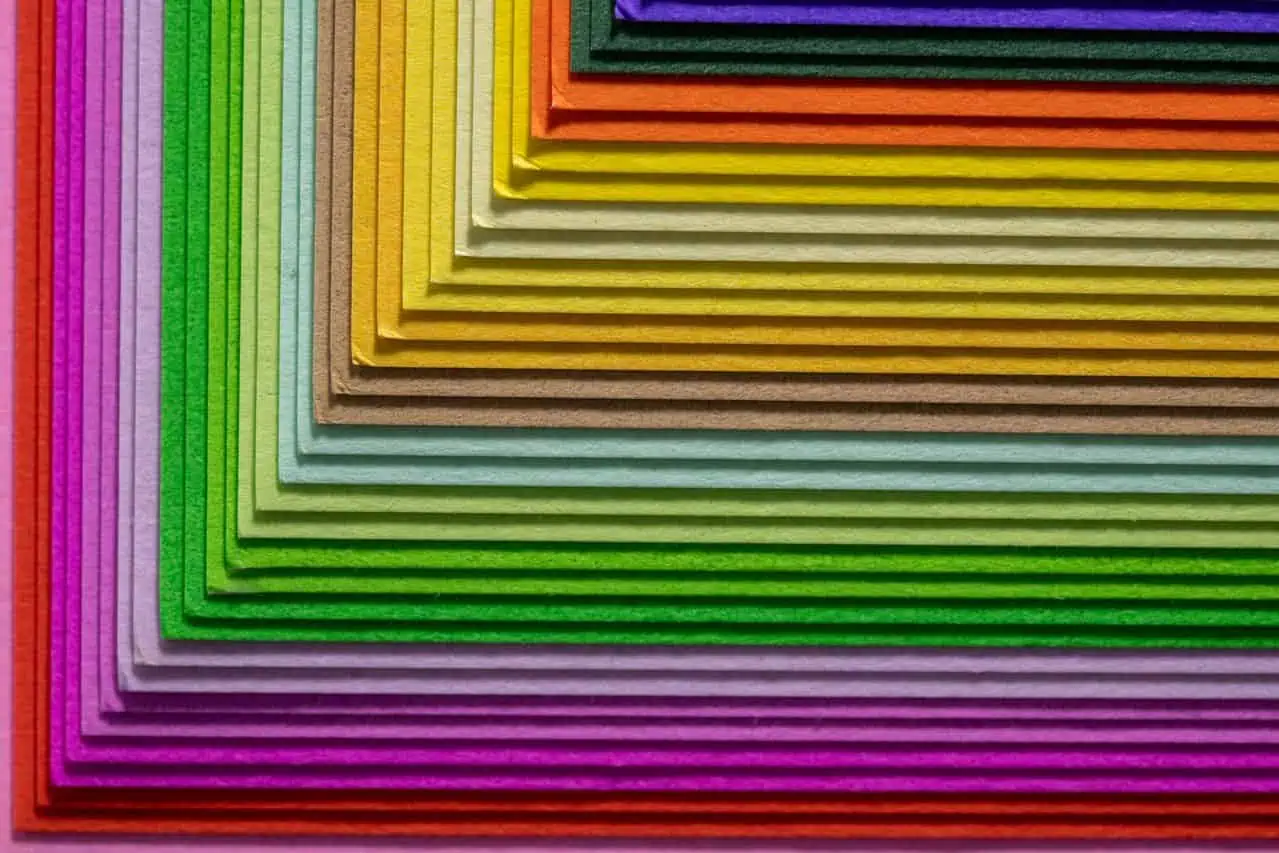 Vibrant geometric arrangement of multicolored paper with a textured surface, creating a layered abstract design.